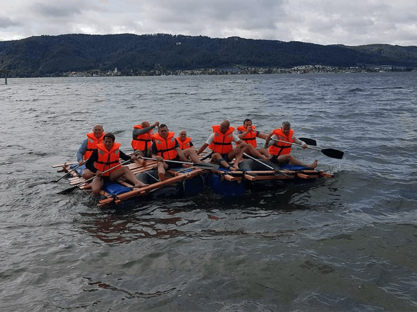 Team baut gemeinsam ein Floss am Schweizer See